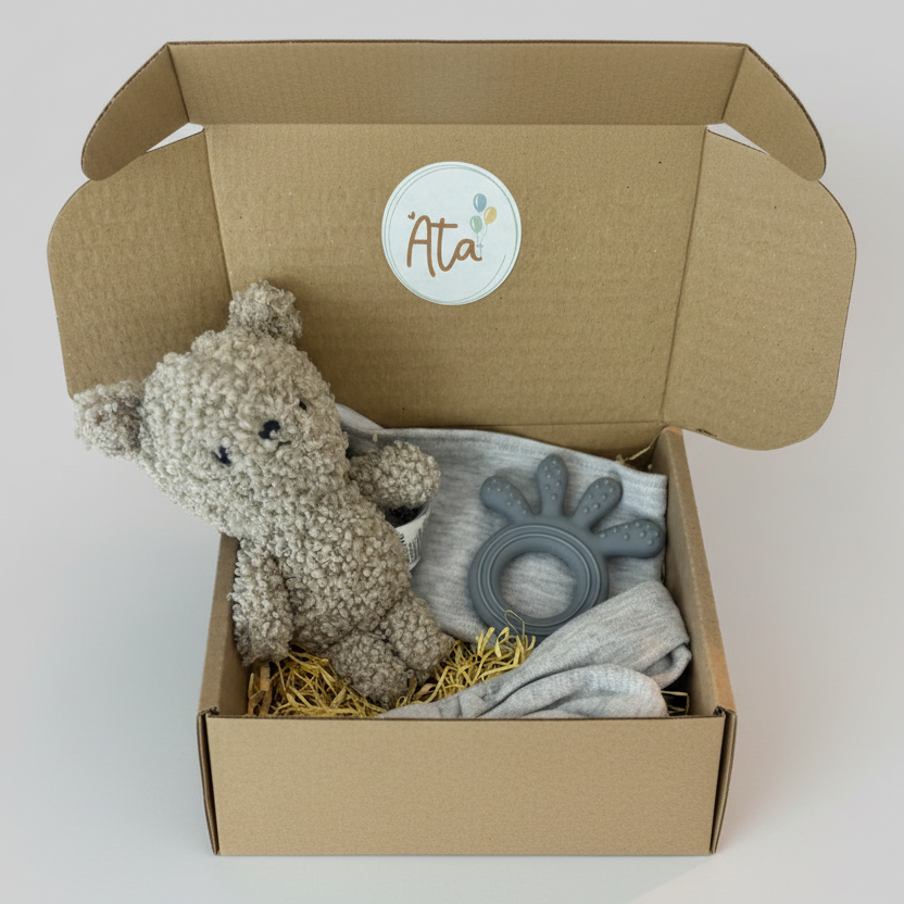 Baby gift set with plush toy, rattle, and blanket in a box, featuring the brand 'Ata'.