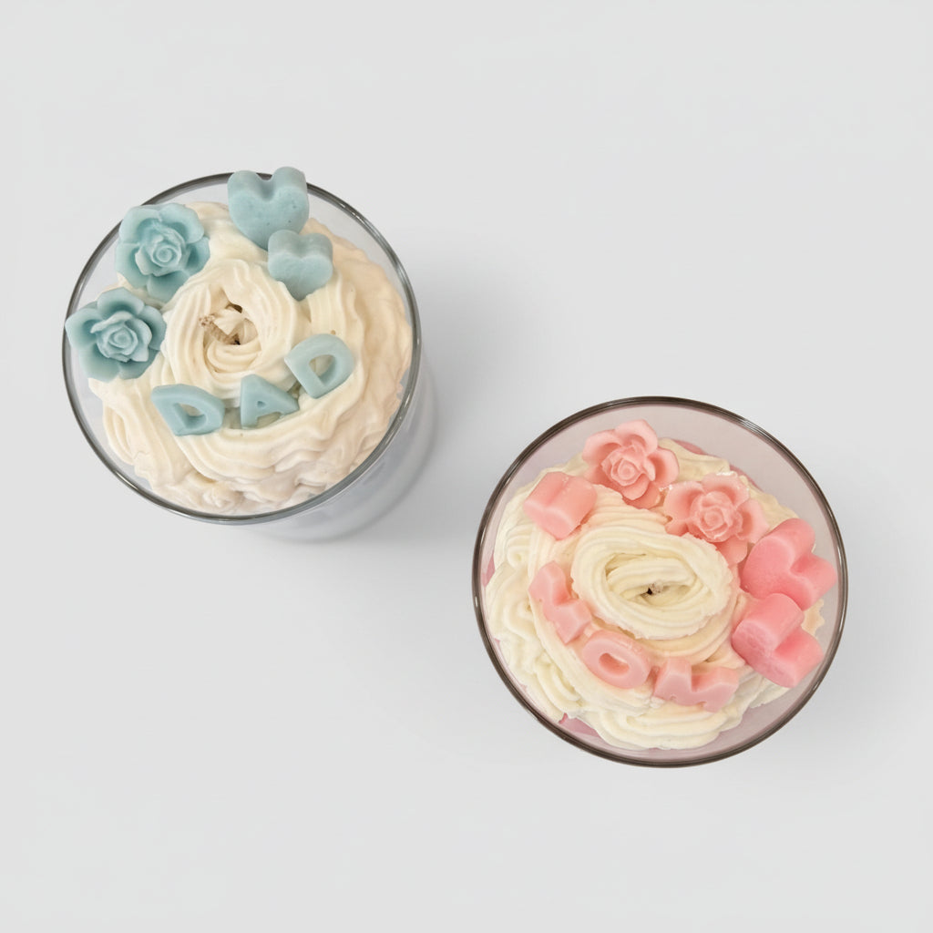 Two cupcake decorated candles blue for dad and pink for mum in a glass