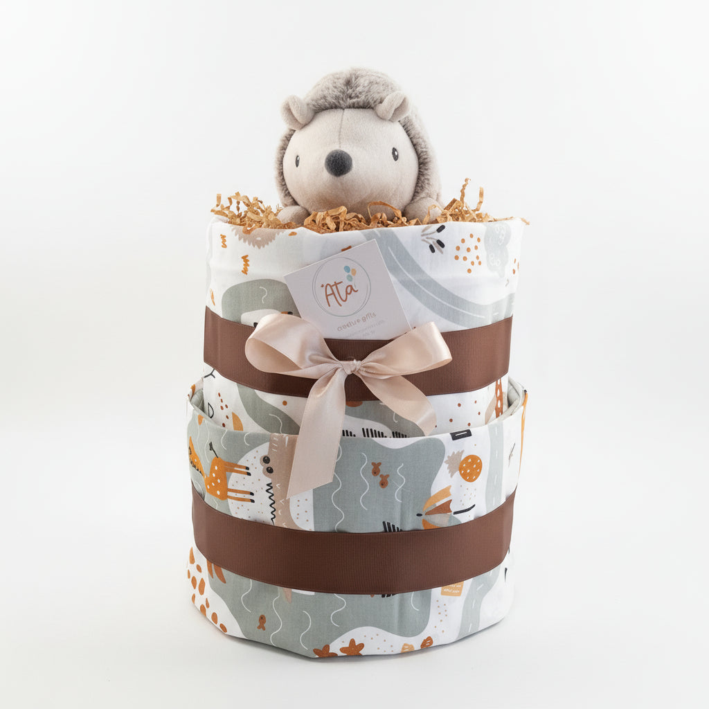 Three-tiered diaper cake with a plush  toy and sheets on a surface