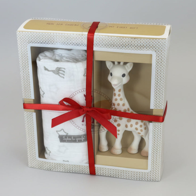 Baby gift set with a giraffe toy and blanket in a decorative box on a grey background